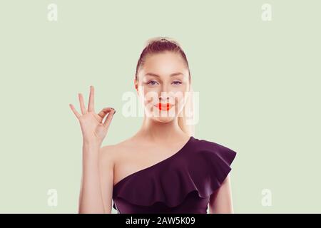 Alles wird gut. Schöne junge Frau mit Ok Zeichen auf hellem Grün Wand Hintergrund isoliert. Positive menschliche Emotionen Gesicht expressi Stockfoto