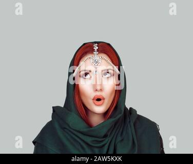 Wunderschönes schockiert Mädchen mit grünem Schal und Tikka-Schmuck, Frau mit großen Augen, mit offenem Monat. Isolierter hellgrau-grauer Hintergrund. Express Stockfoto