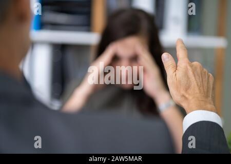 Nahaufnahme der Unternehmer Streiten für junge geschäftsfrau am Schreibtisch Stockfoto