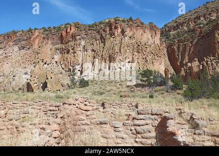 Teil der Tyuonyi-Ruinen der angestammten Pueblo-Völker mit einem rekonstruierten Pueblo an den Klippen entlang des Hauptschleifenweges im Frijoles Canyon bei Ba Stockfoto