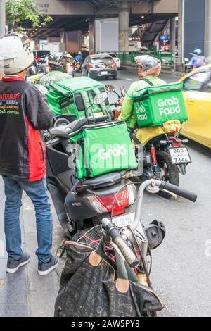 Bangkok, Thailand - 9. Januar 2020: Auf der Sukhumvit Road fahren Lebensmittel-Motorradfahrer. Der Service wird in der Stadt immer beliebter. Stockfoto