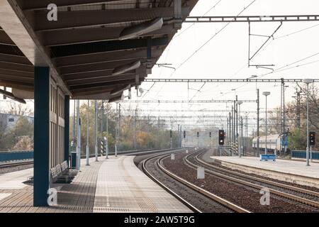 Kürzlich renovierte Gleise auf den modernisierten Bahnsteigen eines Vorortbahnhofs in einer mitteleuropäischen Hauptstadt mit brandneuem Betonstr Stockfoto