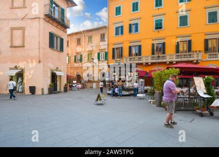 Touristen halten an einem Touristenneuheiten- und Souvenirstand im touristischen Zentrum von Pisa, Italien. Stockfoto