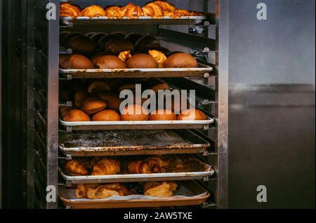 Frisch gebackenes Brot befindet sich auf dem Rollwagen. Kam gerade aus der Bäckerei. Stockfoto