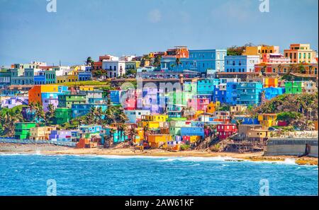 Bunte Häuser führen am Hang über den Blick auf den Strand in San Juan, Puerto Rico Stockfoto