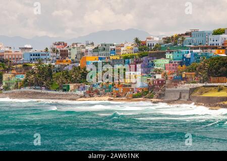 Bunte Häuser führen am Hang über den Blick auf den Strand in San Juan, Puerto Rico. Stockfoto