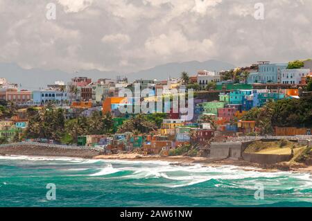 Bunte Häuser führen am Hang über den Blick auf den Strand in San Juan, Puerto Rico. Stockfoto