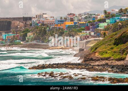 Bunte Häuser führen am Hang über den Blick auf den Strand in San Juan, Puerto Rico. Stockfoto