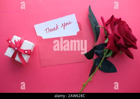 Danke Brief und Rose Blume auf rotem Hintergrund Stockfoto