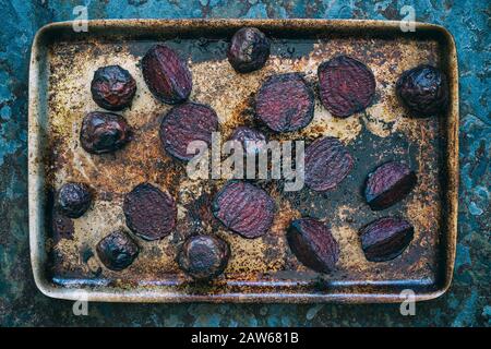 Beta vulgaris. Geröstete rote Bete auf einem Backblech auf Schiefer Stockfoto