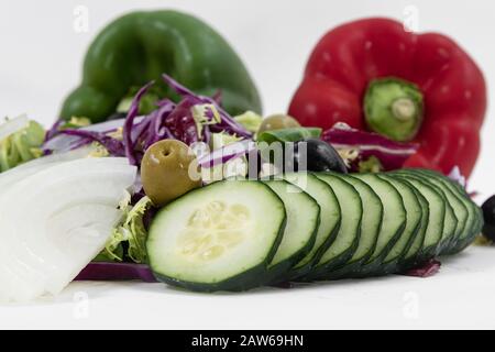 Nahaufnahme von geschnittenen Gurken, gehackten Rotkohl, Oliven, Spinat und gehackten Zwiebeln Stockfoto
