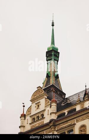 Eine kunstvoll verzierte Kuppel und ein Turm schmücken ein tschechisches Jugendstil-Wohngebäude mit Schieferfliesendach. Details der Architektur in Prag, Tschechische Republik Stockfoto