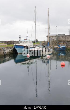 Boote im kleinen Hafen im Fischerdorf Carnlough, einer Stadt in Nordirland. Stockfoto
