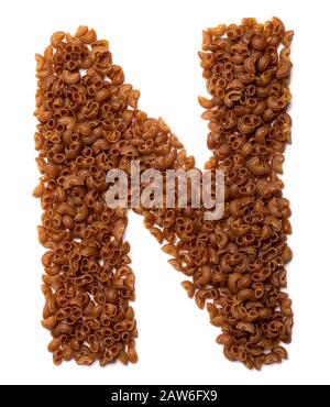 Buchstabe N des englischen Alphabets aus trockener Pasta aus Buchweizenamarthmehl auf weißem isoliertem Hintergrund. Lebensmittelmuster aus Makkaroni-Röhrchen. Stockfoto