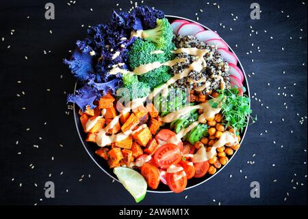 Vegane Buddhaschüssel mit Quinoa, gebackene Süßkartoffel, rote Kale, würzige Kichererbsen, Avocado und Mikrogrüns. Gesunde ausgewogene Ernährung. Draufsicht Stockfoto