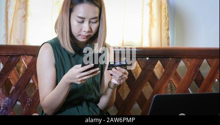Frau asiatische mit Smartphone und Kreditkarte online einkaufen Stockfoto