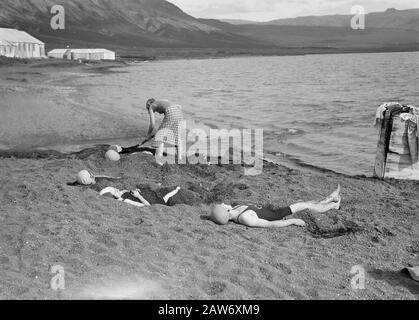 Island Laugarvatn. Mädchen begraben andere Mädchen unter heißer vulkanischer Asche am Ufer eines Sees mit warmem Wasser Datum: 1934 Ort: Island, Laugarvatn Schlüsselwörter: Landschaften, Mädchen, Seen, Zelte, Hitze, Wasser Stockfoto