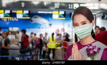 Pattaya, THAILAND - 4. FEBRUAR 2020: Air Hostess Willkommen standee tragen Schutzmaske am Check-in-Bereich, U-Tapao International Airport Terminal während Stockfoto