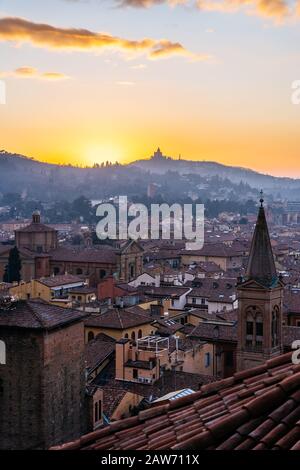 Sonnenuntergang in Bologna, Blick auf Dächer und Hügel mit Kloster San Luca. Stockfoto