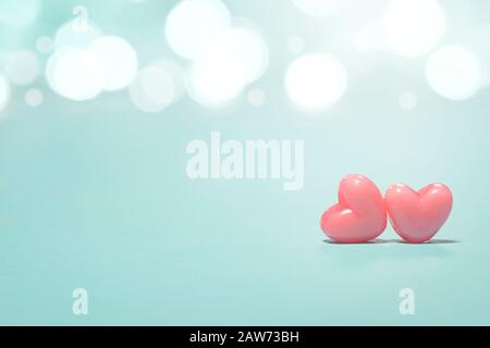 Das rosafarbene Herz formt sich auf abstraktem Lichtglitzerhintergrund im Liebeskonzept für Valentinstag mit süßem und romantischem Moment Stockfoto