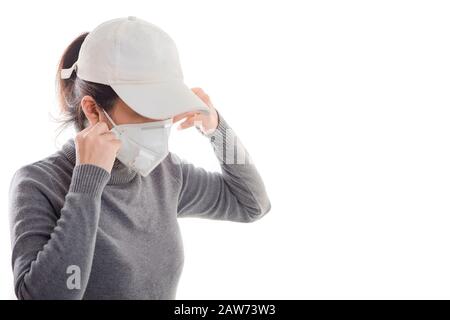 Frau mit grauem Hemd, die eine Maske trägt, die auf weißem Hintergrund isoliert ist. Die Förderung von Menschen verwendet Gesichtsmaske, um sich vor Virusinfektionen in Corona zu schützen Stockfoto