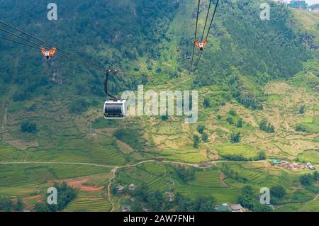 Sapa, Vietnam - 20. August 2017: Seilbahn mit Reisterrassen über grünes Bergtal. Reiseabenteuer Hintergrund Stockfoto