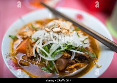 Nahaufnahme der traditionellen vietnamesischen Pho-Suppe in einer Schüssel mit Holzstäbchen. Authentische vietnamesische Küche in der Nähe Stockfoto