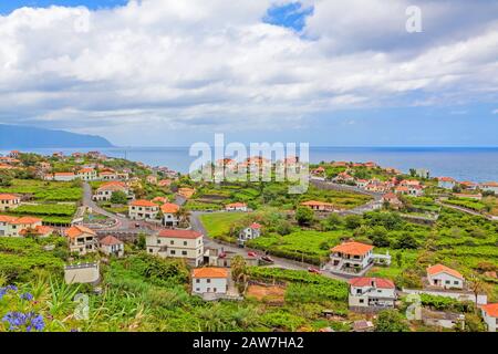 Ponta Delgada, Madeira - 7. Juni 2013: Blick über die Stadt Ponta Delgada, Nordküste Madeiras - typische kleine Häuser mit orangefarbenen Dächern in grüner Natur - Stockfoto