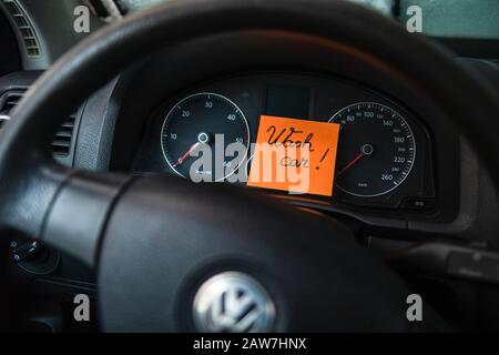 Waschwagen auf Memo-Post-Erinnerung schreiben. Text auf Haftpapier im Armaturenbrett des Fahrzeugs. Stockfoto