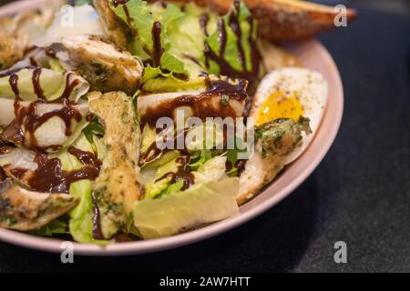 Köstlicher cäsar-salat mit Hühnchen Hühnersalat. Cäsar-Salat mit gegrilltem Huhn, gekochtem Ei und frischen Grüns auf dem Teller. Stockfoto