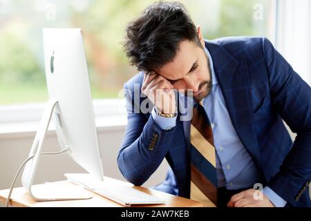 Mann saß nachdenklich am Computer Stockfoto