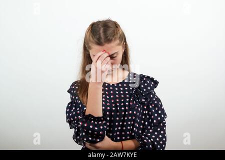 Mädchen in einem schwarzen Kleid mit weißen Kreisen, die verzweifelt verärgert waren, beugten sich den Kopf und traurig Stockfoto