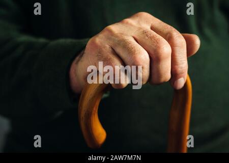Hand eines alten Mannes, der im Dunkeln hervorgehoben wurde Stockfoto