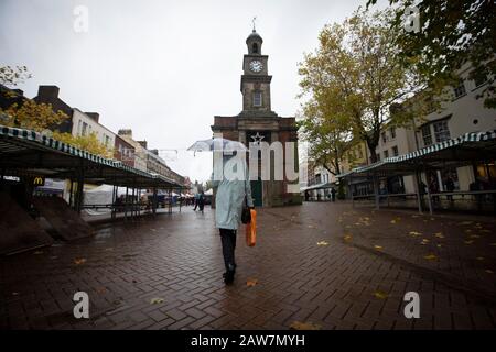 Eine Frau, die durch einen Markt im Zentrum der Stadt Newcastle-under-Lyme in Staffordshire in den Midlands von England läuft. Die Stadt wird bei den bevorstehenden Parlamentswahlen im Vereinigten Königreich 2019 abstimmen. Derzeitiger Abgeordneter für den Wahlkreis Newcastle-under-Lyme ist Paul Farrelly von der Labour Party. Stockfoto