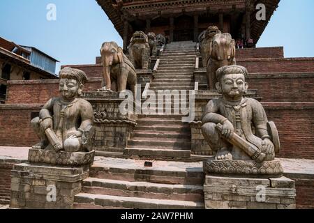Treppenaufgang, flankiert von Steinfiguren der Tempelwächter im Nyatapola-Tempel in Bhaktapur, Kathmandu-Tal, Nepal Stockfoto