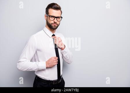 Foto von gut aussehenden jungen Macho-Business-Mann, der sich auf ein Firmenmeeting vorbereitet, mit stylischen schwarzen Krawatte, mit weißen Bürotrikots, schwarze Hosen isoliert Stockfoto