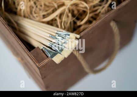 Neue Holz-Lackbürsten auf hellem Hintergrund. Stockfoto