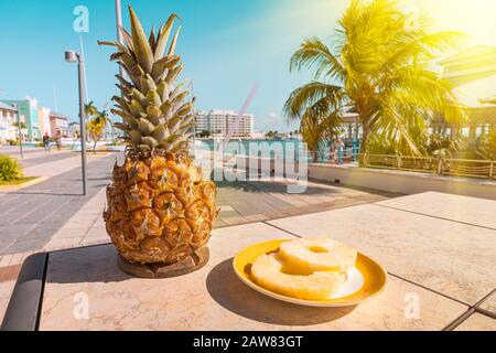 Alkoholischer Cocktail Pina Colada in Ananas auf dem Tisch vor dem Hintergrund des Seehafens. Straßenrestaurant. Im Freien. Sommerliches Erfrischungsgetränk i. Stockfoto