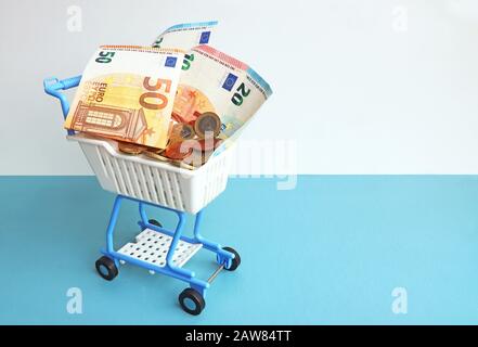 Spielzeug-Supermarkt-Trolley mit Euro-Banknoten und -Münzen gefüllt Stockfoto