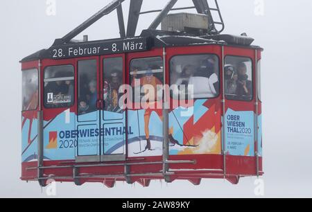 Oberwiesenthal, Deutschland. Februar 2020. Eine Vollgondel der Fichtelbergbahn schwimmt den Fichtelberg hinauf. Am selben Tag beginnen die zweiwöchigen Winterferien in Sachsen. Nach den warmen Tagen mit viel Regen hoffen die sächsischen Skigebiete nun wieder auf kaltes Wetter und Schneefall. Kredit: Jan Woitas / dpa-Zentralbild / dpa / Alamy Live News Stockfoto