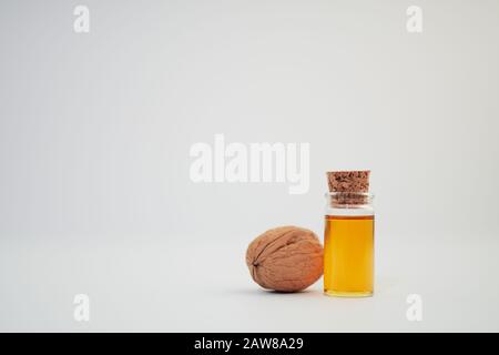 Eine Walnuss (Juglans Regia) und eine Probe Nussöl in einer Glasflasche auf weißem Hintergrund Stockfoto