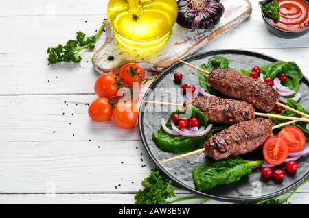 Kebab. Traditionelles mittelöstliches, arabisches oder mediterranes Fleischkebab mit Gemüse und Kräutern. Draufsicht. Freier Speicherplatz für Ihren Text. Stockfoto