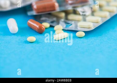 Nahaufnahme verschiedener Arzneipillen und Tabletten auf blauem Hintergrund. Pharmazeutisches oder medizinisches Konzept. Stockfoto