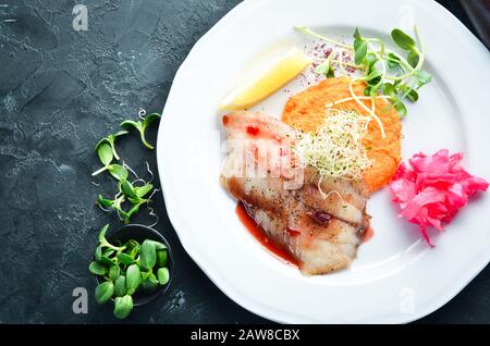 Gebackenes Fischfilet mit Kartoffelpüree. In der Platte. Draufsicht. Freier Speicherplatz für Ihren Text. Rustikaler Stil. Stockfoto