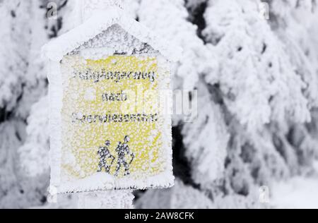 Oberwiesenthal, Deutschland. Februar 2020. Ein eisiger Schild zeigt den Weg zum Wanderweg nach Oberwiesenthal. Am selben Tag beginnen die zweiwöchigen Winterferien in Sachsen. Nach den warmen Tagen mit viel Regen hoffen die sächsischen Skigebiete wieder auf kaltes Wetter, vorzugsweise verbunden mit Schneefall. Kredit: Jan Woitas / dpa-Zentralbild / dpa / Alamy Live News Stockfoto