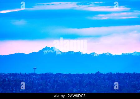 Blick auf die Stadt Seattle in der Abenddämmerung und den Gipfel des Olymp im Hintergrund mit Häusern aus Bellevue, Washington WA, USA Stockfoto