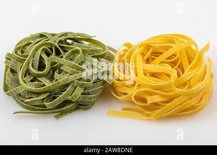 Ungekochte Tagliatelle Pasta, grün und gelb, zwei Nester Stockfoto