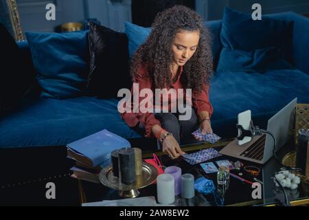 Junge Frau, die Tarot-Karten auslegt Stockfoto