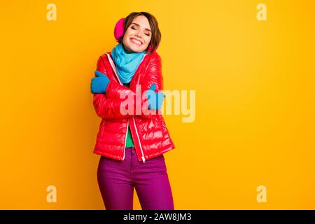 Foto von Amazing Lady genießen Sie warmen Mantel bei kaltem Frosty Wetter Umarmung selbst tragen Sie stylische legere kurze rote Überwolle blaue Schal Handschuhe Ohrmuscheln Hosen Stockfoto