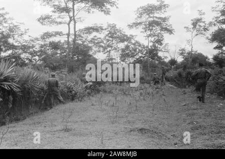 Tapanoelis [2. Polizeiaktion] [niederländische Soldaten sind über das offene Feld gelangt und verstecken sich in den umliegenden Büschen] Datum: 25. Dezember 1948 Ort: Indonesien, Niederländische Ostindien, Sumatra Stockfoto